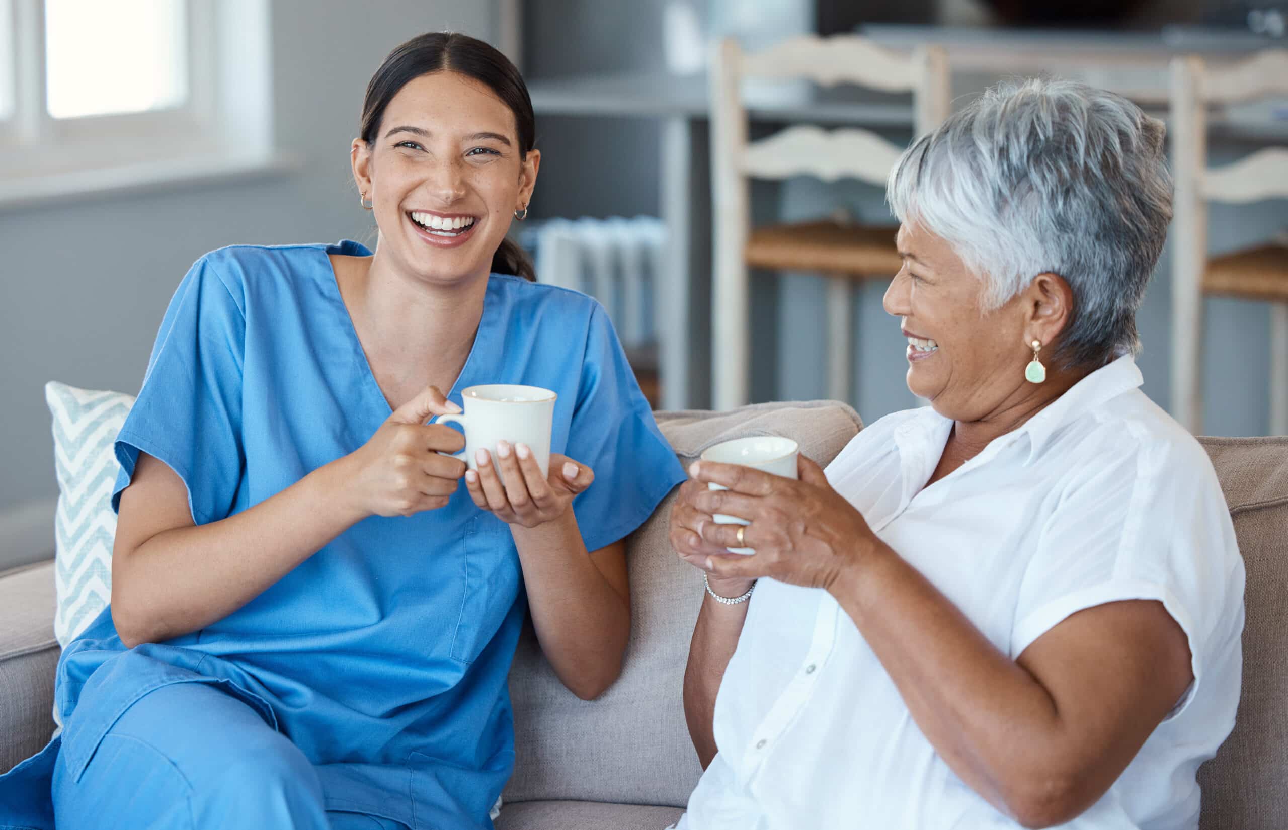 nurse and woman having coffee and laughing