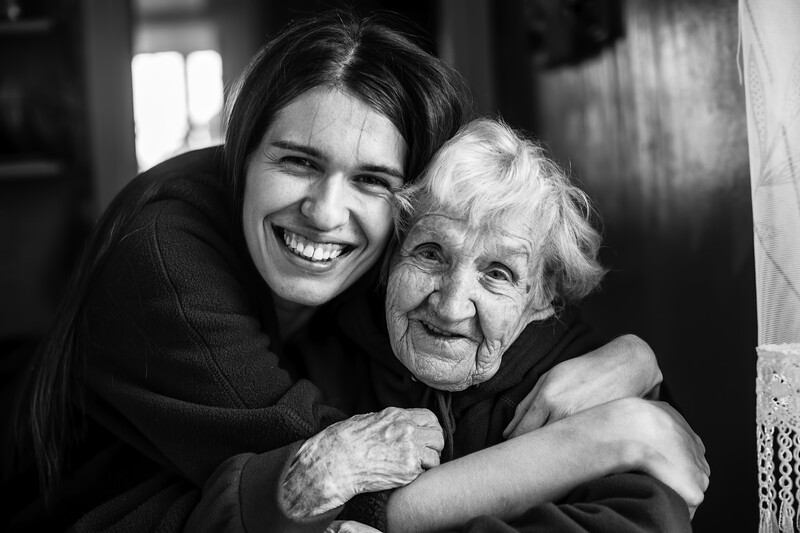 caregiver hugging senior woman
