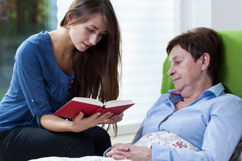 caregiver reading to woman